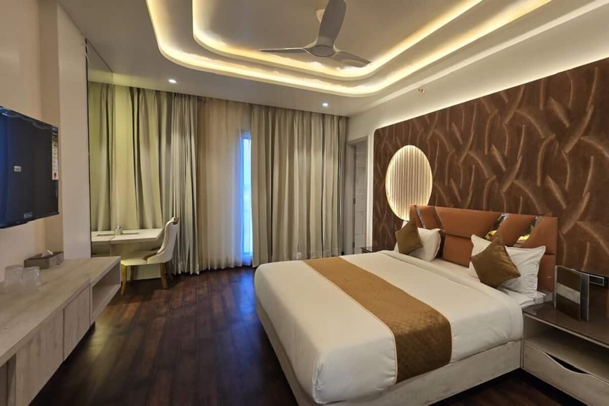 Una habitación de hotel moderna con una cama grande, un escritorio y un tocador.