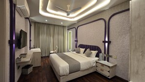Un dormitorio moderno con una cama grande, mesitas de noche, un tocador y un ventilador de techo.