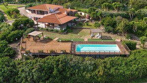 A large house with a swimming pool, surrounded by lush greenery and a well-maintained garden. - Villa 'Patrizia' with Sea View, Wi-Fi and Air Conditioning (Castelsardo)