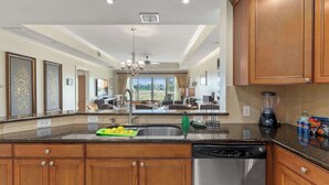 A kitchen with wooden cabinets, a dishwasher, a sink, and a countertop with a blender and snacks. - Bright home near Disney w/ themed rooms & pool (Kissimmee)