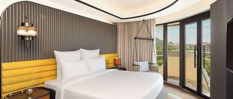 A modern hotel room with a large bed, a hanging chair, and a balcony with a city view.