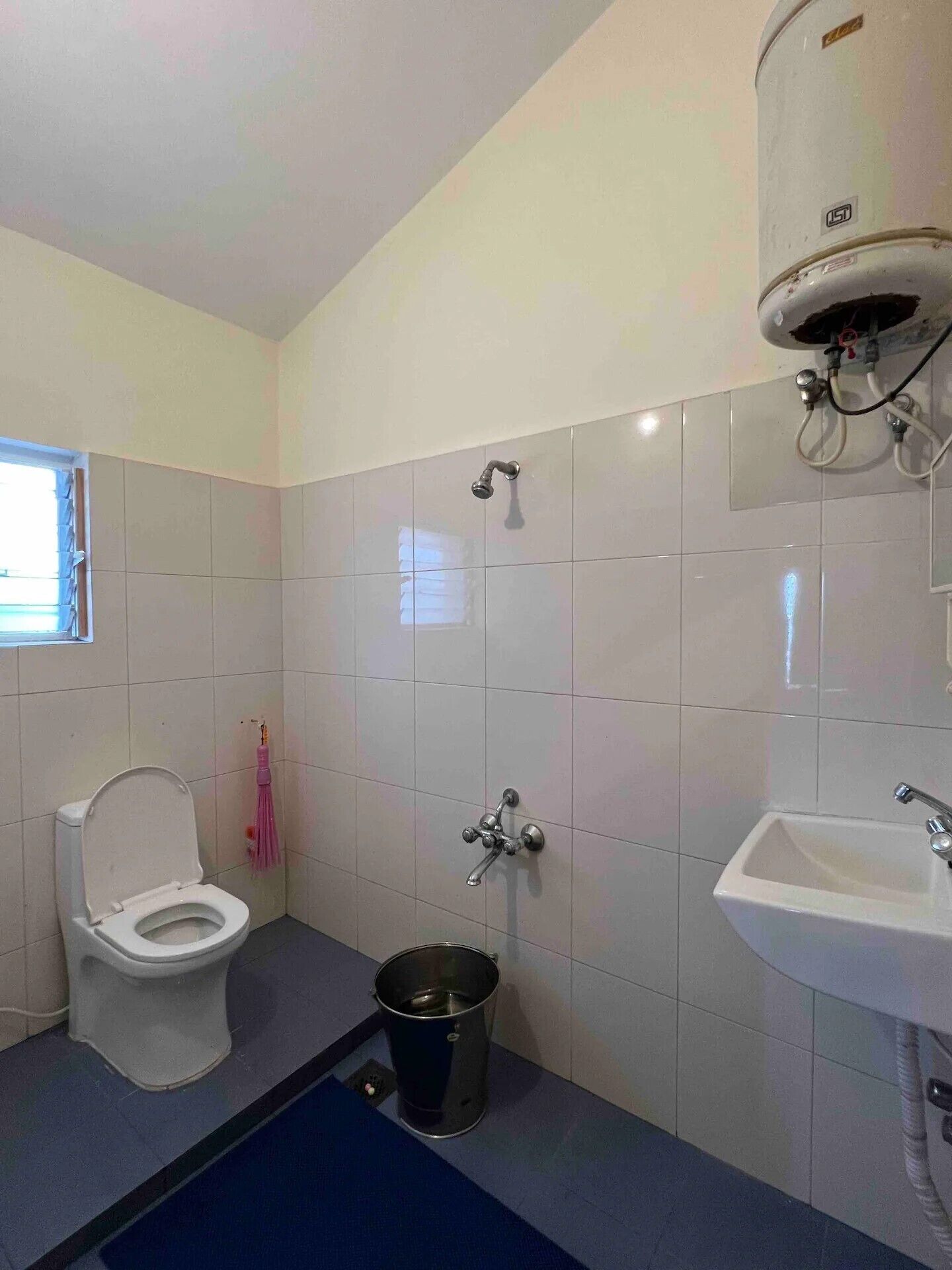 Un baño con inodoro, bidé, lavamanos y ducha.