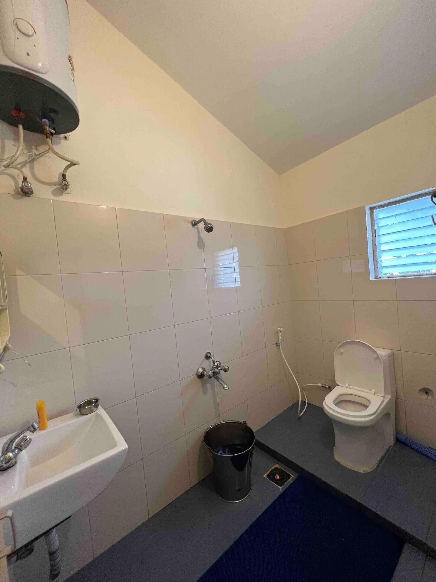 A small bathroom with a sink, toilet, and shower.