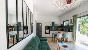 Een moderne keuken met een eethoek, een groene bank en een grote spiegel.