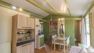 Une cuisine compacte avec des meubles en bois, un coin repas avec une table et des chaises, et un petit coin salon avec un canapé.