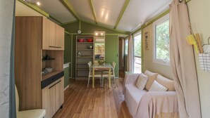 Une cuisine compacte avec des meubles en bois, une table à manger et un canapé.