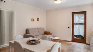 Un salon moderne avec un canapé, une table à manger et une petite table d’appoint.