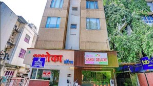 A multi-story building with a sign for 'Hotel Garci Deluxe' and a visible electric vehicle charging station. - Hotel Gargi Deluxe (Pune)