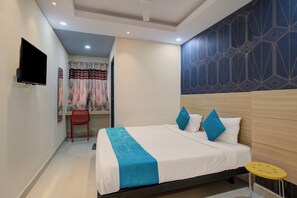 A modern hotel room with a bed, a TV, a red chair, and a yellow stool. - Botanica Luxury Living Space, Gachibowli, Hyderabad (Hyderabad)