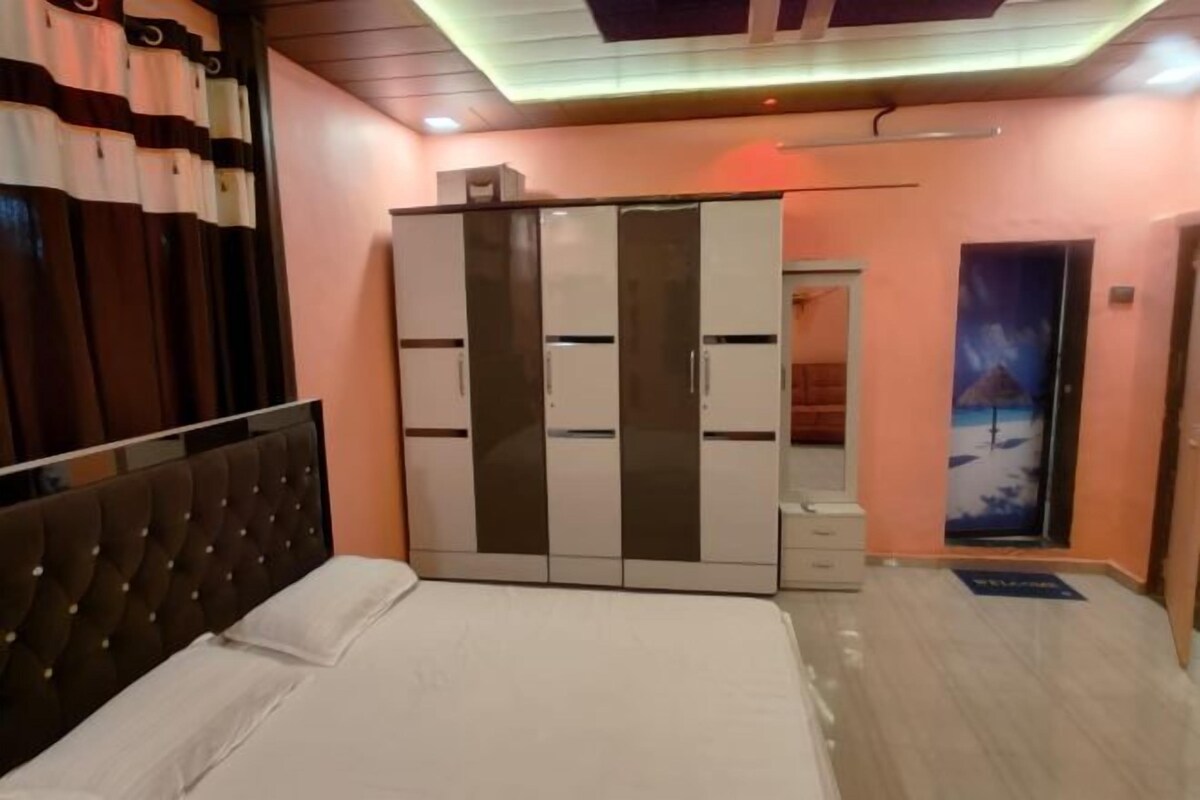 A bedroom with a bed, wardrobe, and a door leading to another room.