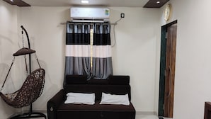 A room with a bed, a hanging chair, a curtain, and a clock on the wall. - My Village Home (Murbad)