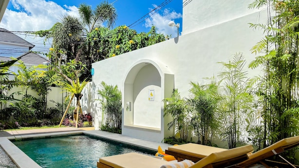 A pool area with lounge chairs, a small pool, and lush greenery. - Villa Andra Canggu (Canggu)