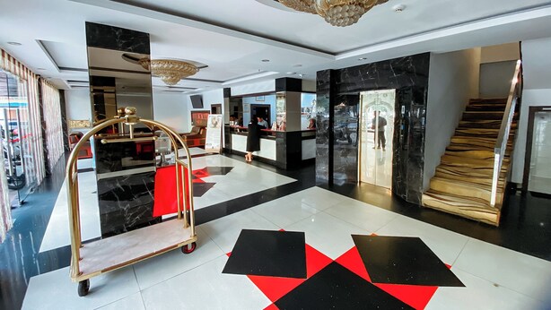 A hotel lobby with a check-in counter, a reception desk, and a staircase. - Lucky Star Hotel Near Harbour Bay Batam (Batam)