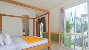 Une chambre à coucher avec un lit à baldaquin en bois, un bureau vert et une chaise.