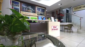 A reception area with a glass desk, wicker chairs, and a potted plant. - YP Boutique Hotel, Paradigm Mall Petaling Jaya (Petaling Jaya)