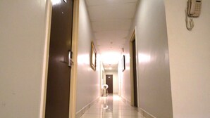 A hotel hallway with a polished floor, doors on both sides, and a telephone mounted on the wall. - YP Boutique Hotel, Paradigm Mall Petaling Jaya (Petaling Jaya)