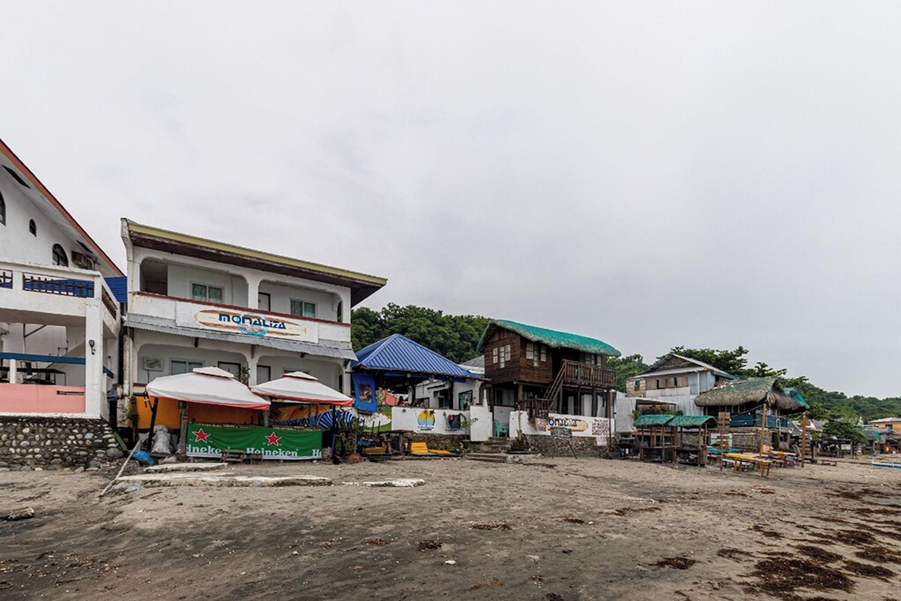 A beachfront area with buildings, including a restaurant named 'Monaliza' and a Heineken bar.