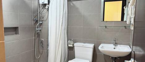 Un baño con ducha, inodoro, lavabo y espejo con marco amarillo.