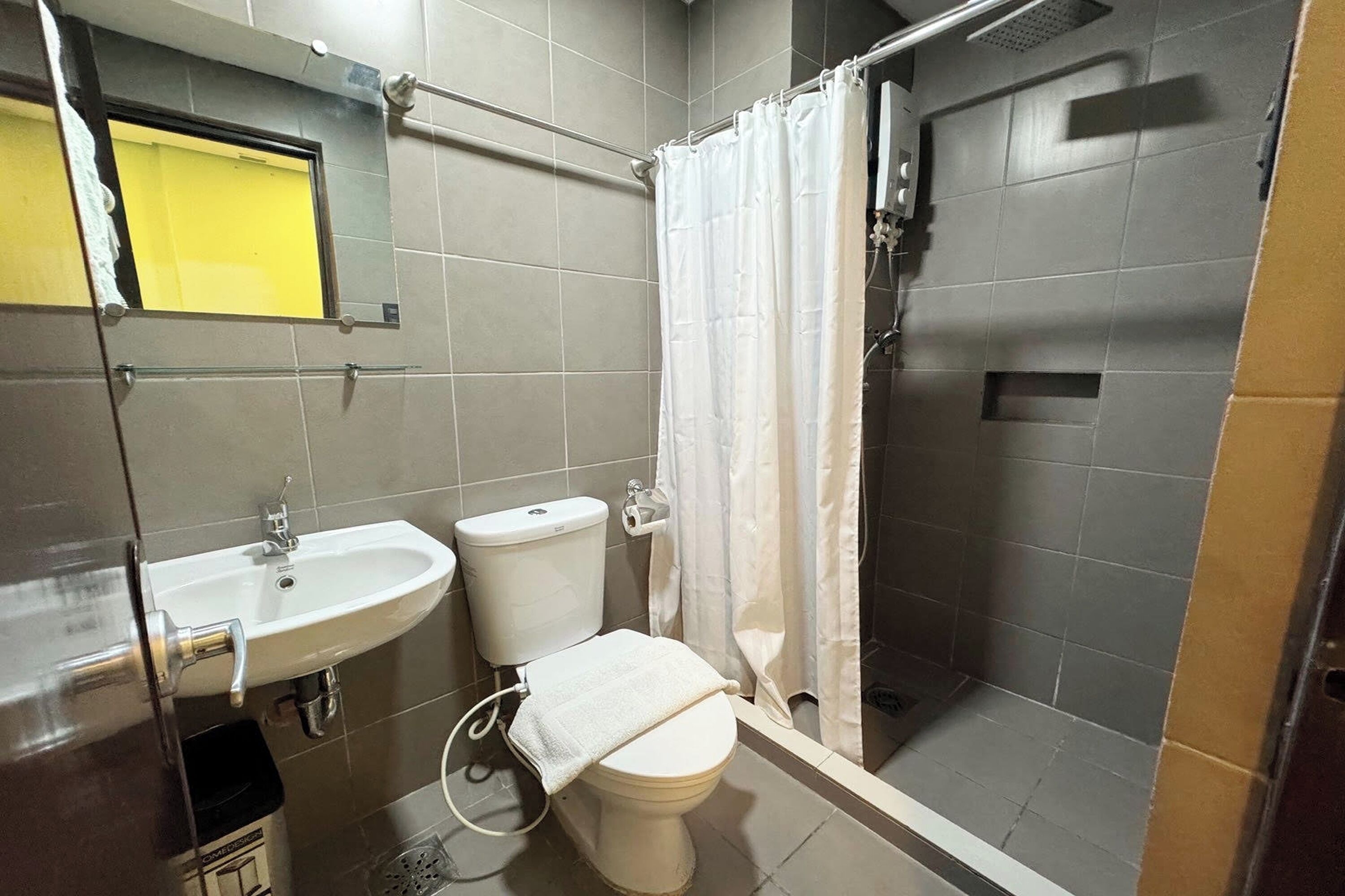 A bathroom with a sink, toilet, and shower area.