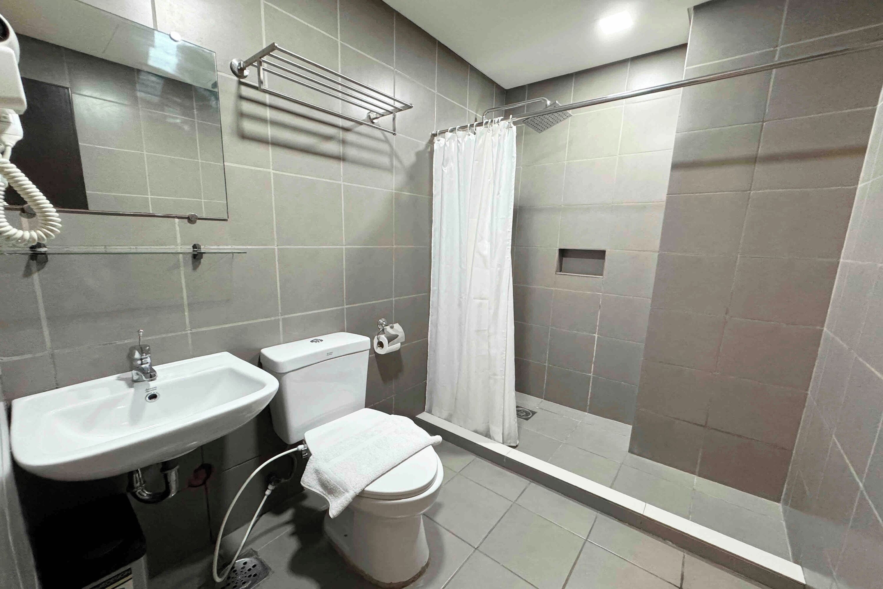 Un bagno con lavandino, WC e doccia.