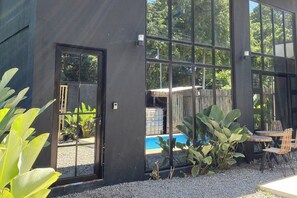 A modern building with large windows, a pool, and outdoor seating. - Casa Calungsod La Union (San Juan)