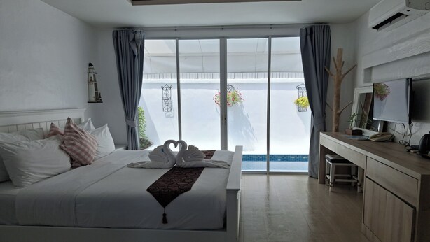 Une chambre d’hôtel avec un grand lit, un bureau et une vue sur la mer.
