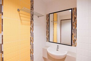 A bathroom with a white sink, a mirror, and a towel rack. - The Nine Place (Hat Yai)