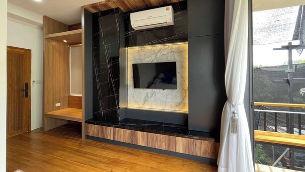 Una sala de estar moderna con chimenea empotrada, televisor montado y un ventanal con vistas al exterior.