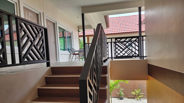 A staircase with a black railing leading to a balcony. - 99 House (Pattaya)