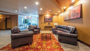 A lobby with leather sofas, a patterned rug, a painting, and a wooden ceiling. - Mountain Plaza 310  1 BD/ 2 BA (Copper Mountain)