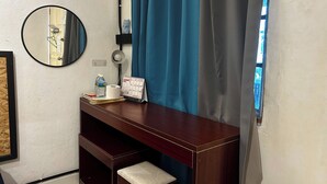 A small, dark wooden desk with a mirror, a lamp, a calendar, and some personal items. - Riverbank Dungun Guesthouse & Cafe (Dungun)