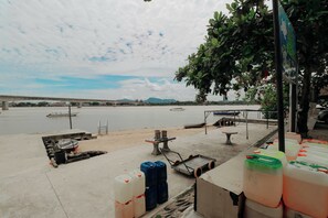 A riverside area with a concrete dock, a table, and several large containers.