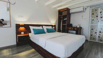 A bedroom with a wooden bed, two bedside lamps, a wardrobe, and a mirror.