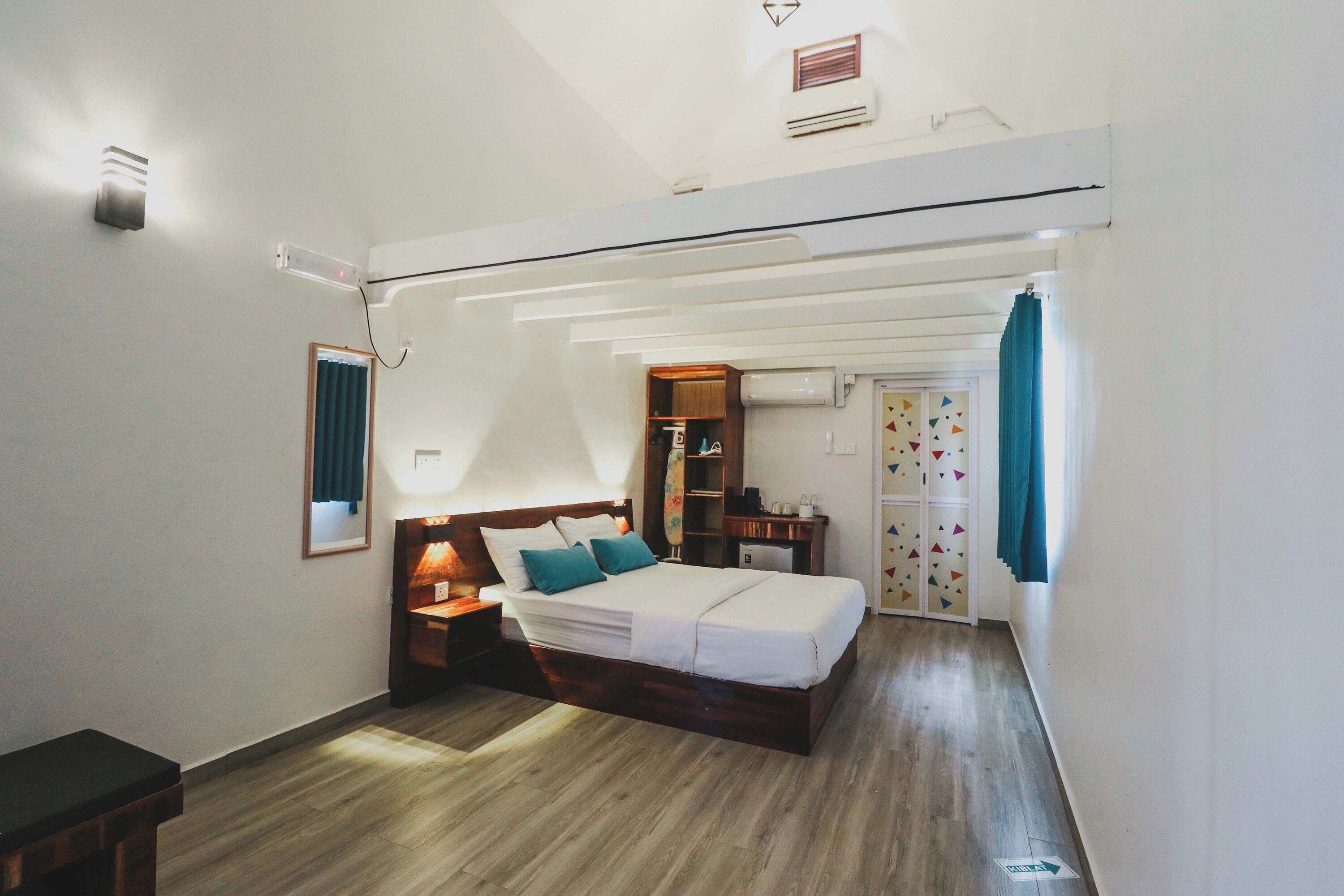 A bedroom with a bed, bedside tables, a wardrobe, and a small desk with a chair.