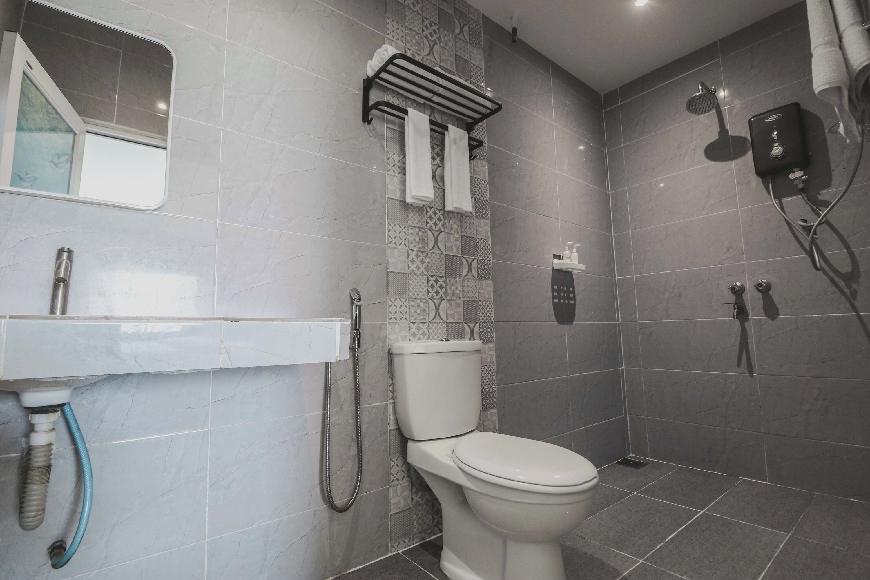 A modern bathroom with a toilet, shower, and sink.