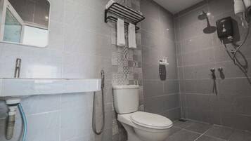 A modern bathroom with a toilet, shower, and sink.