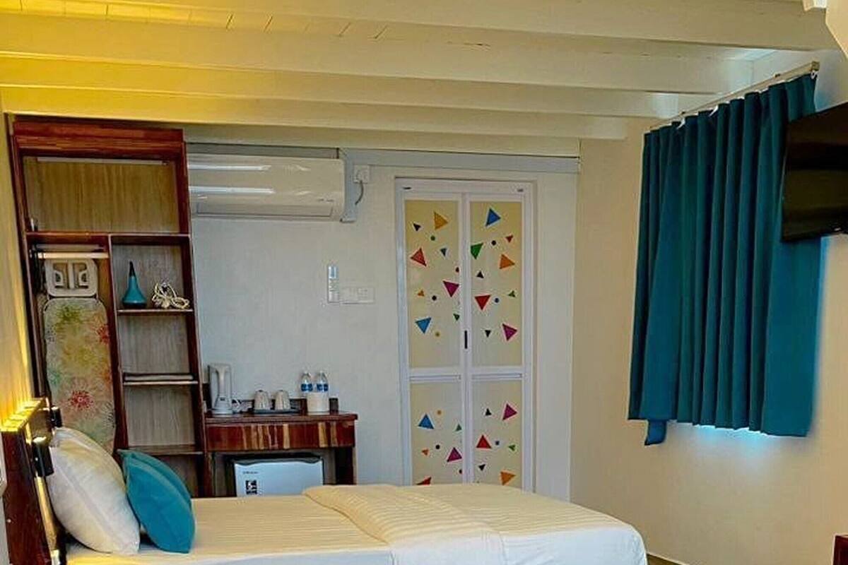 Un dormitorio con cama, escritorio, armario y baño.