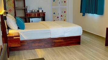 A bedroom with a bed, a desk, a wardrobe, and a bathroom.