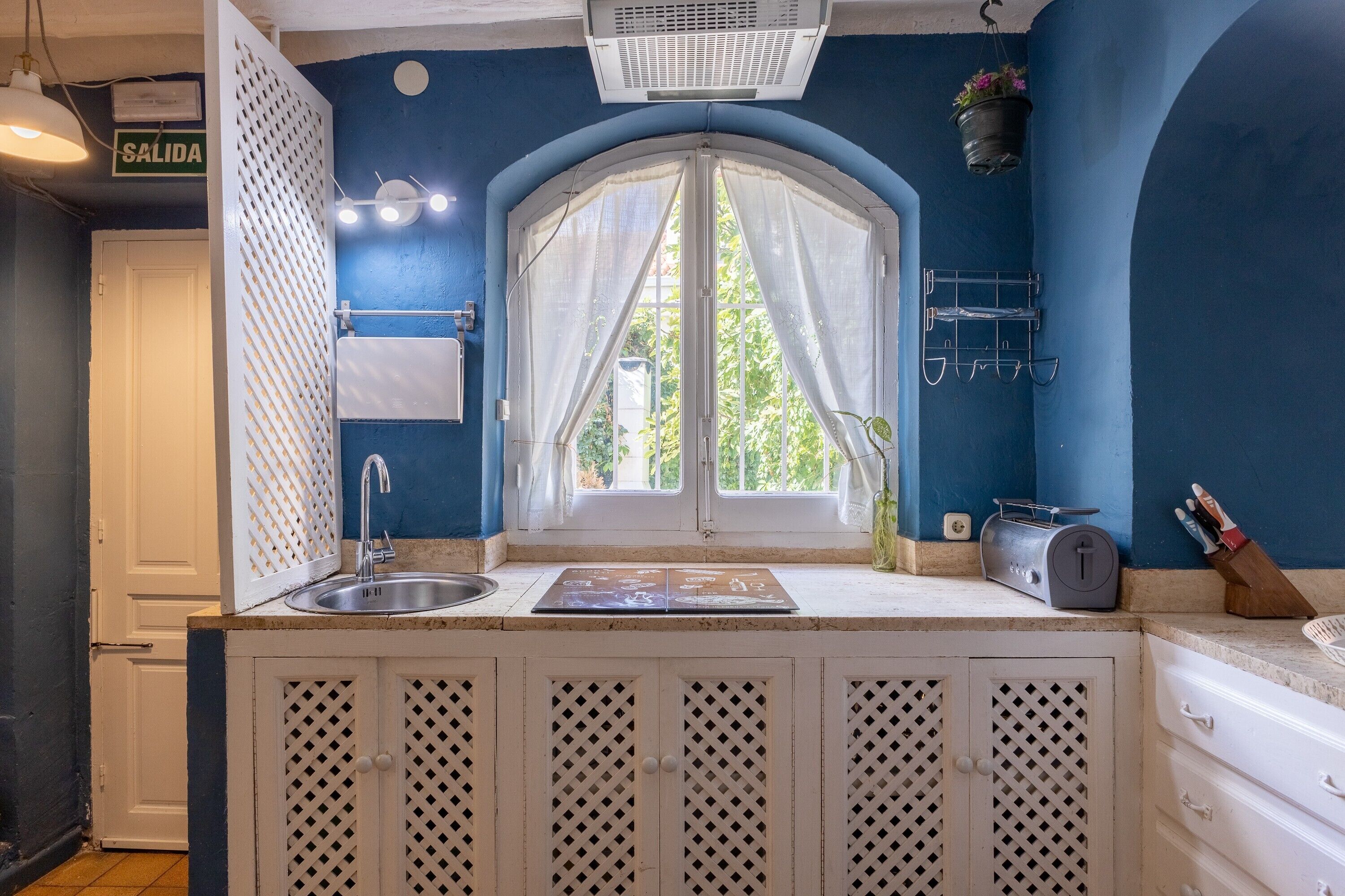 A kitchen with a window, sink, and cabinets.