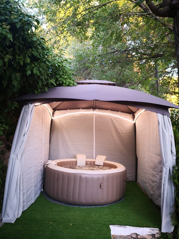 A hot tub with a canopy, surrounded by greenery. - Rural Apartment La Buganvilla with Pool near Chinchón and Aranjuez (VALDELAGUNA)