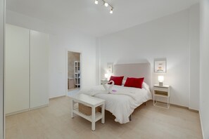 Ein Schlafzimmer mit Bett, Nachttischen, Schreibtisch und Kleiderschrank.