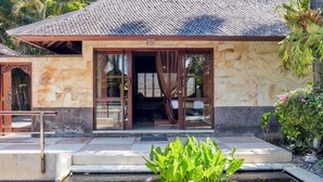 A building with a tiled roof, large glass doors, and a small pond with water lilies.