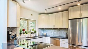 Una cocina moderna con una isla central, electrodomésticos de acero inoxidable y salpicadero con un diseño geométrico.
