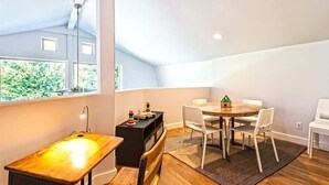 Una habitación moderna con comedor, mesa de masajes y vistas a zonas verdes.