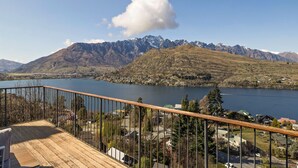 Une terrasse donnant sur un lac, avec des montagnes en arrière-plan.