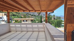 Un espacio al aire libre cubierto con vistas a una colina y edificios al fondo.