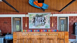 A bar area with a sign reading "Rock Hill Adventures & Resorts" and a poster above it. - Rockhill Adventures And Resorts (Roha)