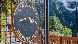A sign with 'L'AIGUILLE DEPUIS 1618' and a mountain graphic.