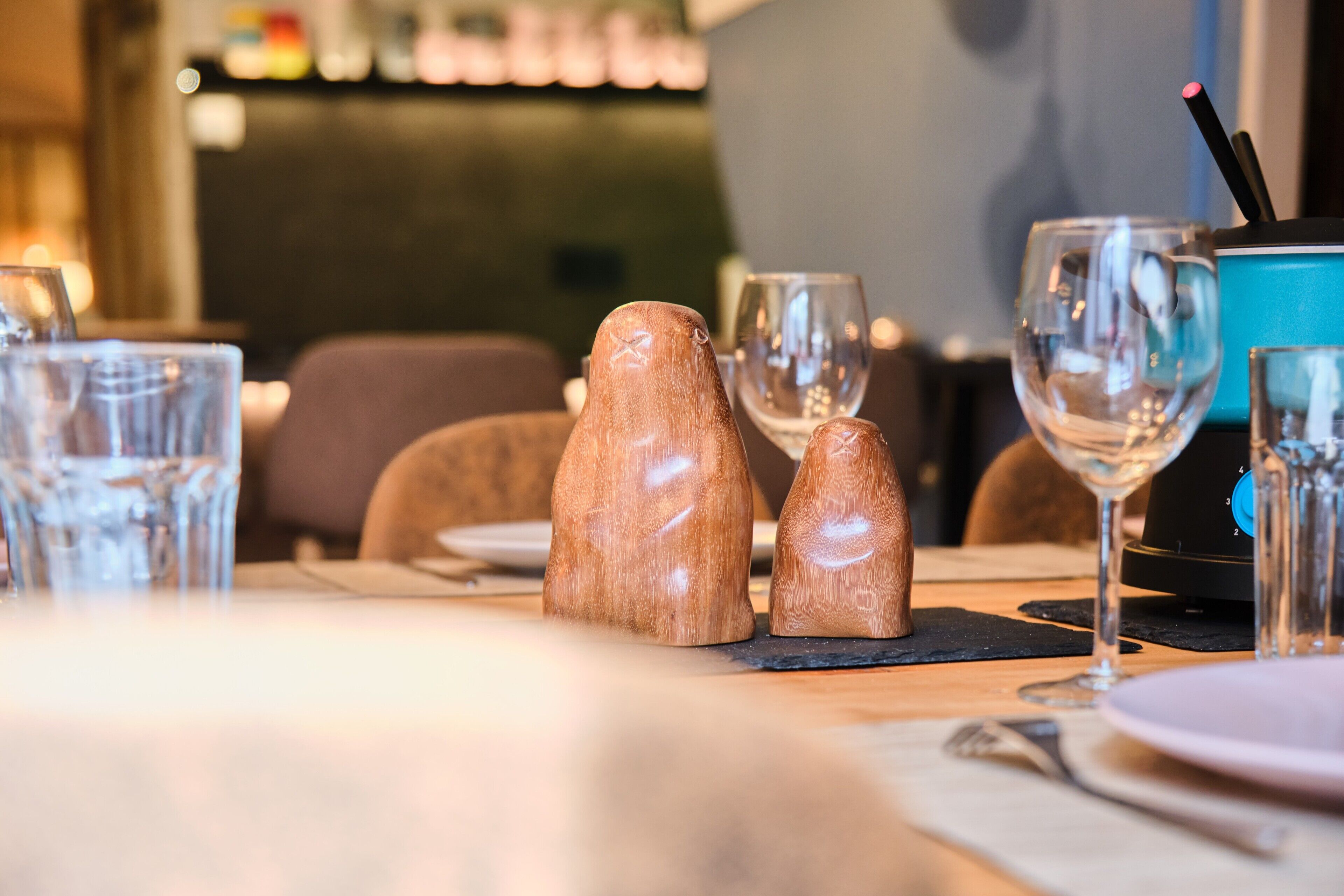 A dining table with salt and pepper shakers, wine glasses, and a blue water dispenser.