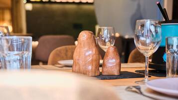 A dining table with salt and pepper shakers, wine glasses, and a blue water dispenser.